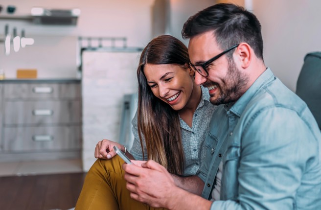 Couple looking at mobile phone and smiling